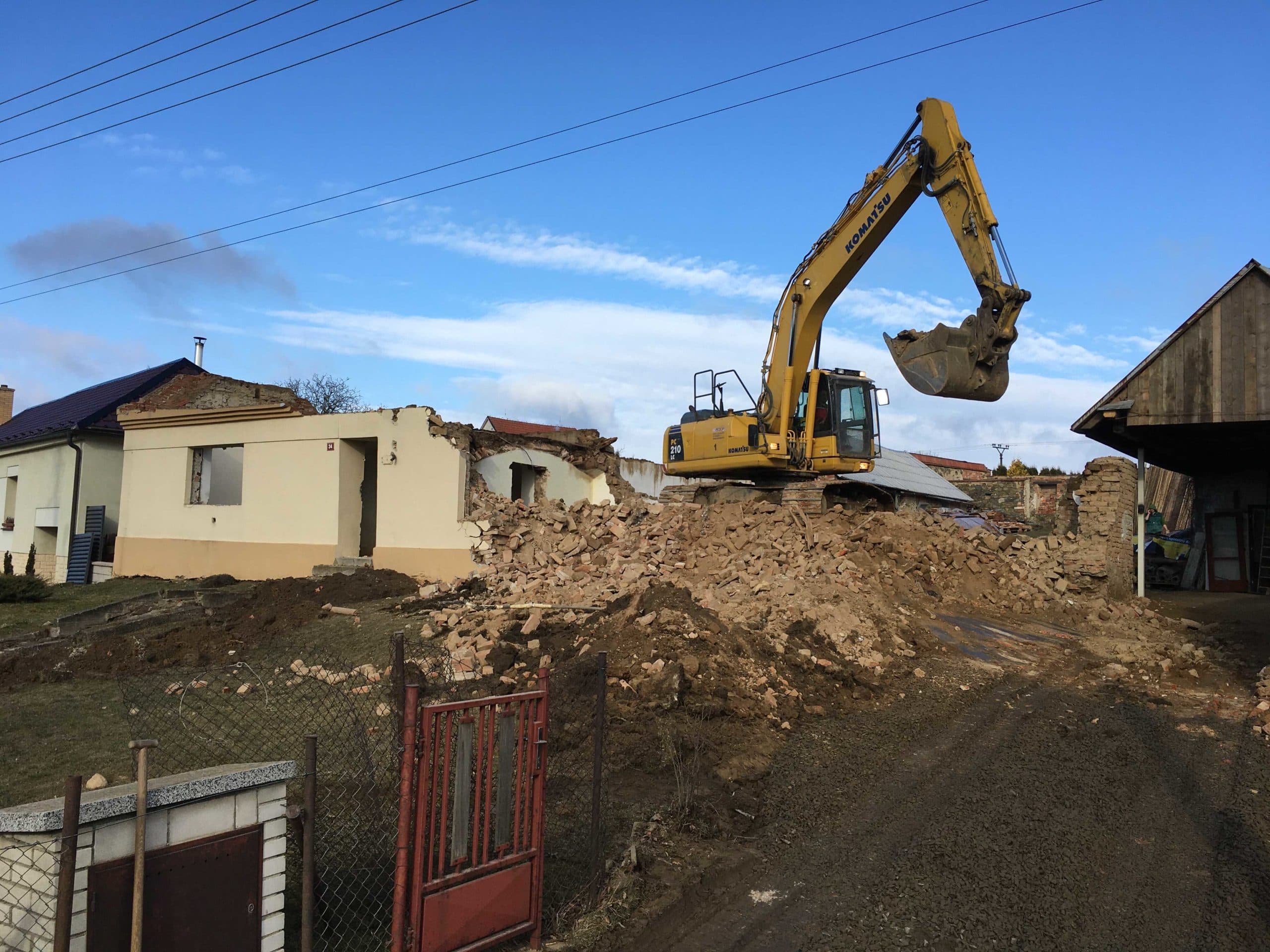 Rypadlo Komatsu PC210 při demolici domu v obci